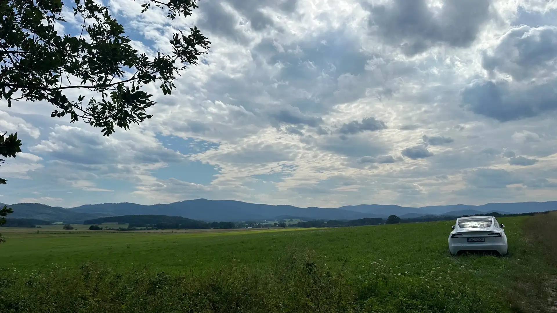View from Johanka to the Rychleby Mountains — green field, mountains on the horizon